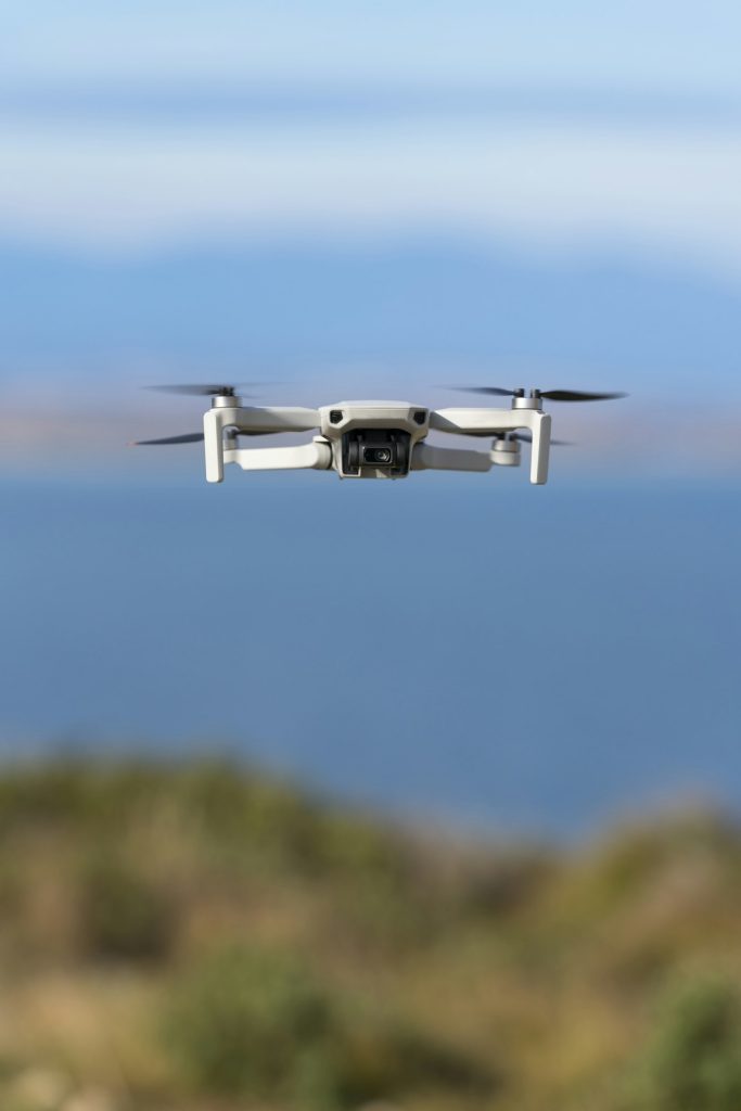 Small drone flying still with a defocused sea background
